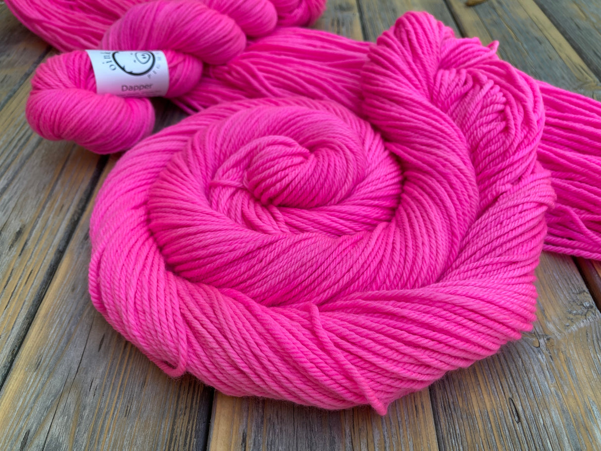 A pile of bright pink rests at a dramatic angle on a wooden background.