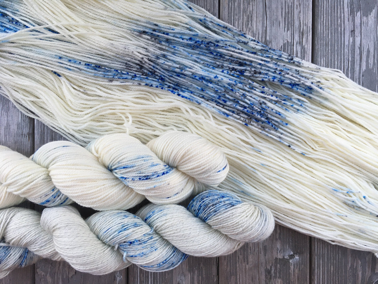 Delicate blue and grey speckles in a sea of cream against a wooden background.
