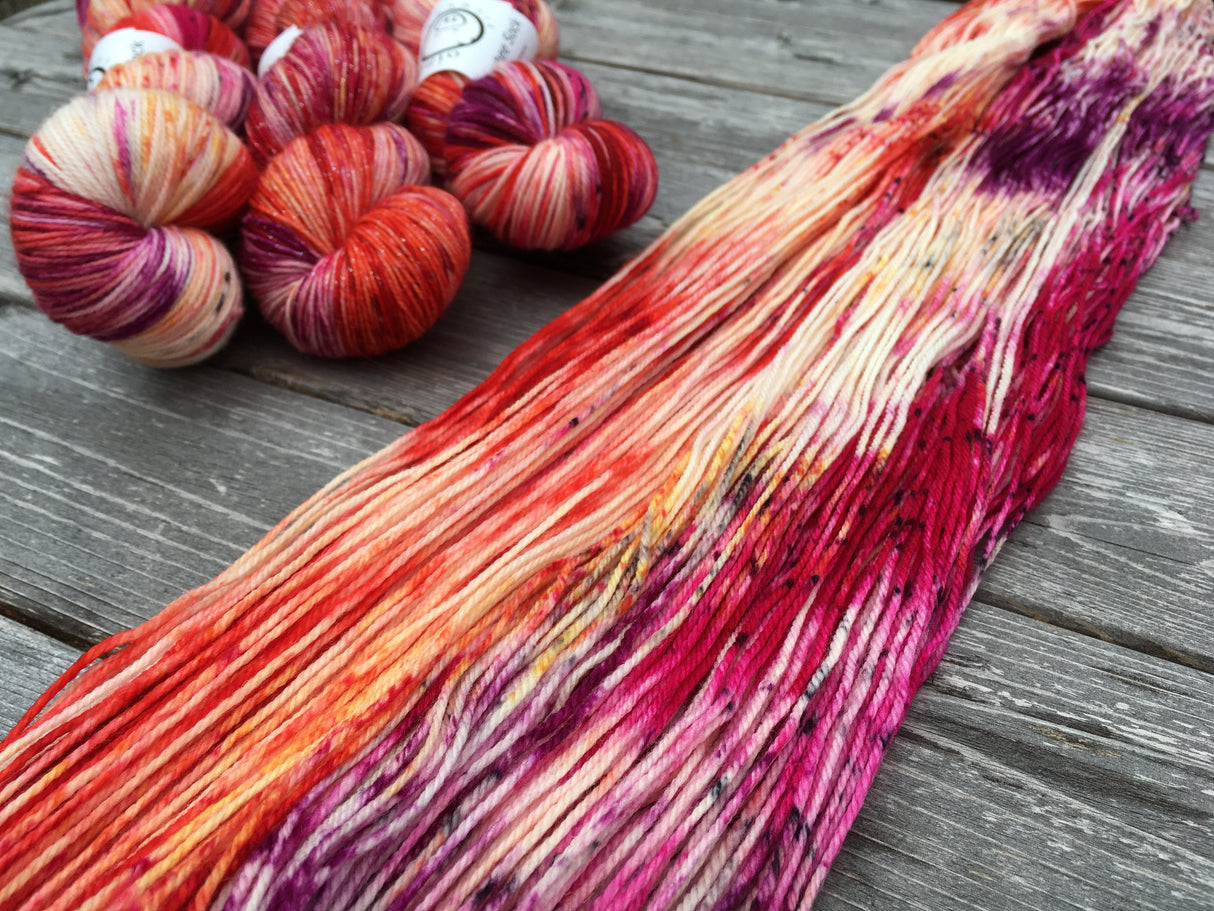 The ends of three twisted skeins rest in the upper left corner while an untwisted hank runs diagonally to the right of the frame.