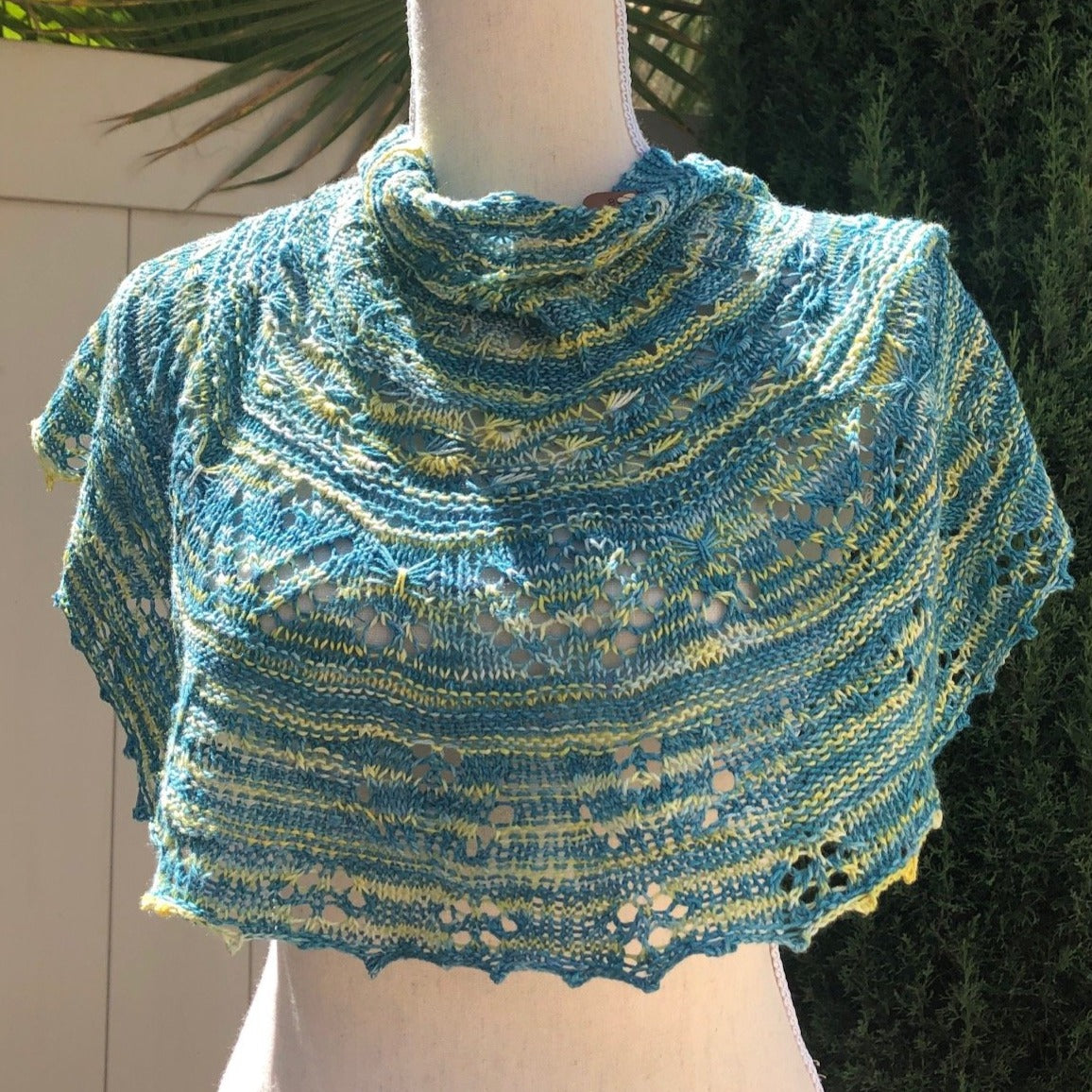 A cowlette featuring delicate eyelet lace and textural garter rounds drapes elegantly on a bodyform.