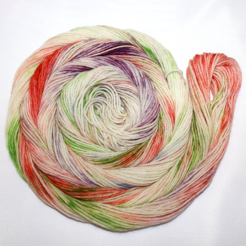 A bright swirl of yarn curls around itself like a labyrinth against a white background.