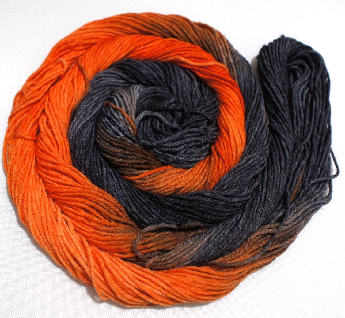 A bright swirl of yarn curls around itself like a labyrinth against a white background.