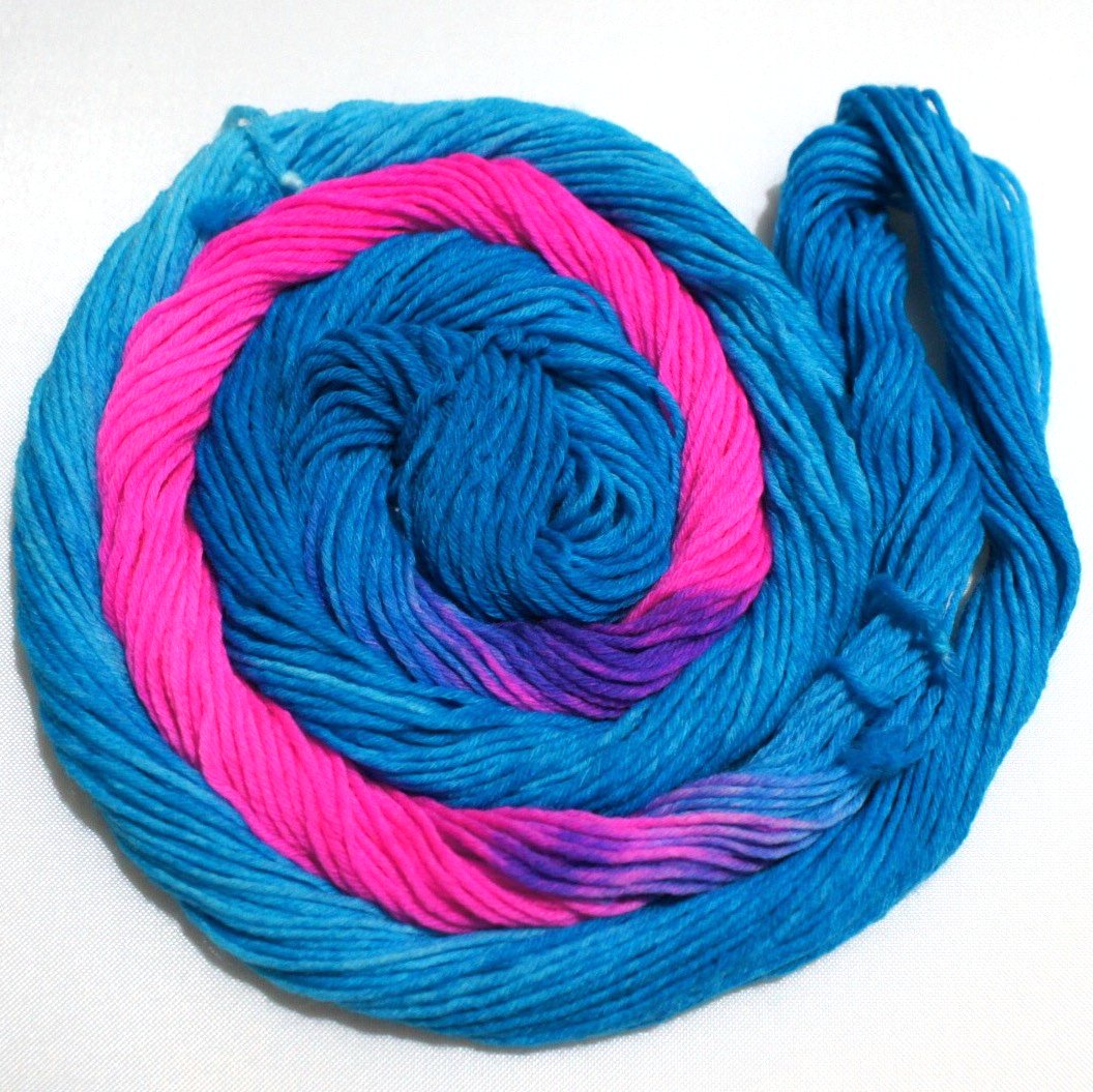 A bright swirl of yarn curls around itself like a labyrinth against a white background.
