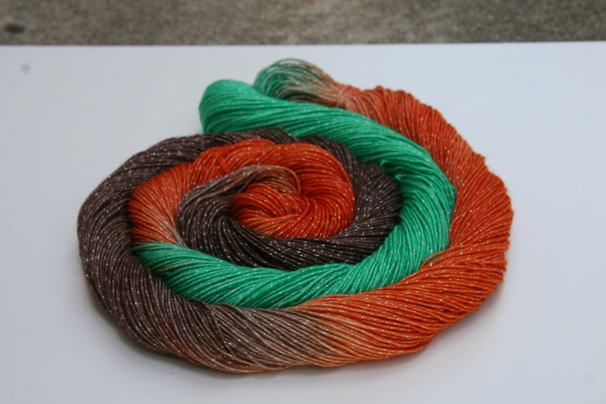 A colorful swirl of yarn with soft sparkles curls around itself on a crisp white background.