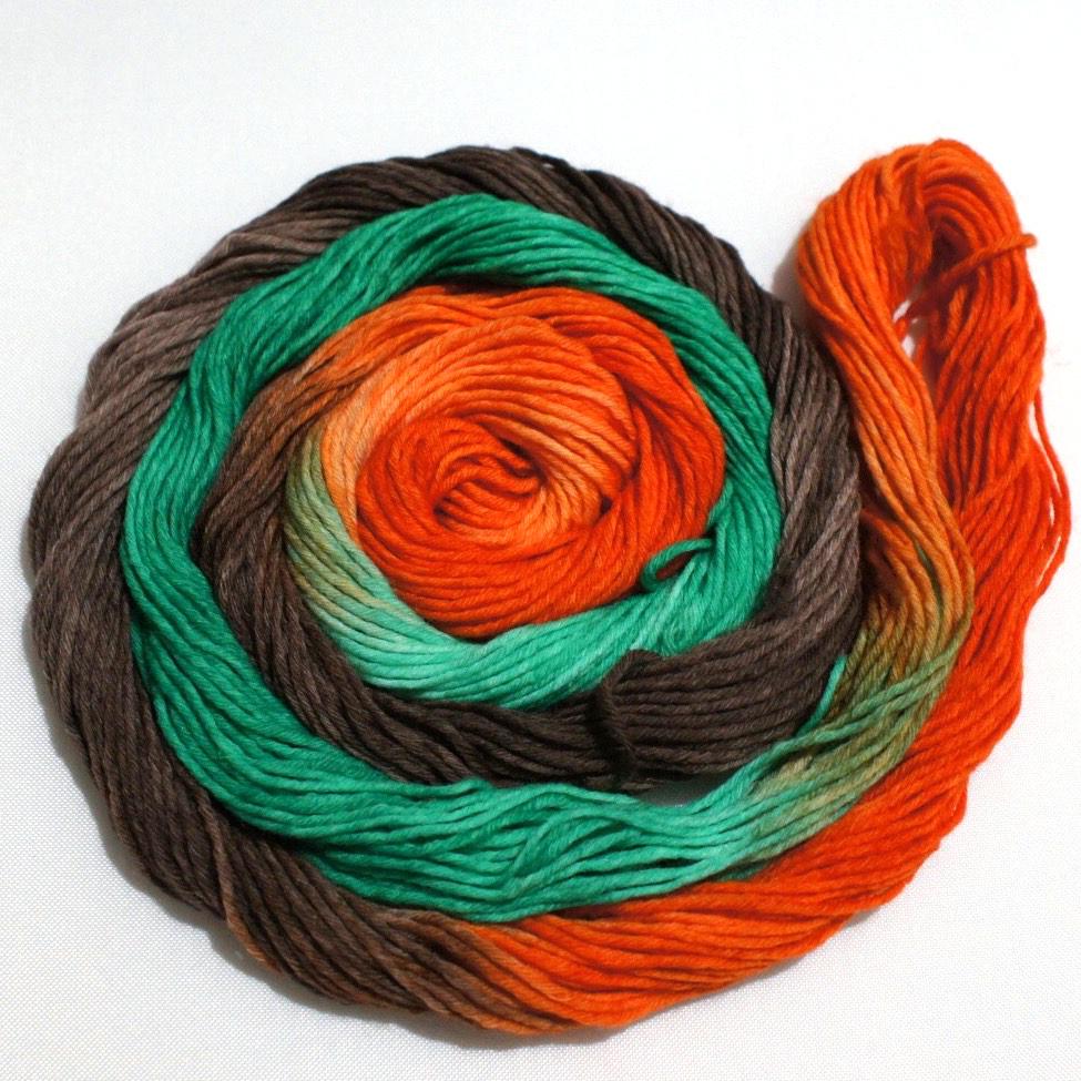 A bright swirl of yarn curls around itself like a labyrinth against a white background.