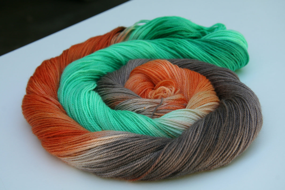 A bright swirl of yarn curls around itself like a labyrinth against a white background.