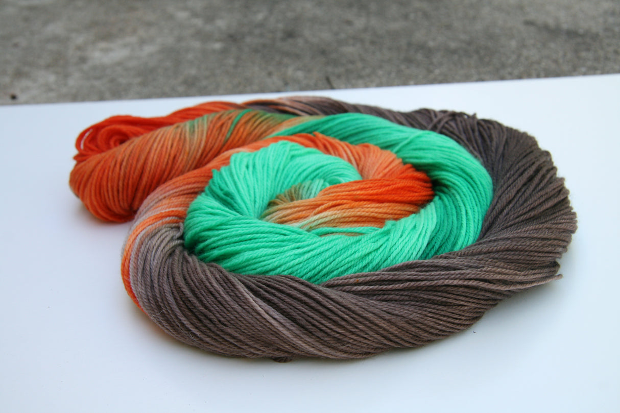 A bright swirl of yarn curls around itself like a labyrinth against a white background.