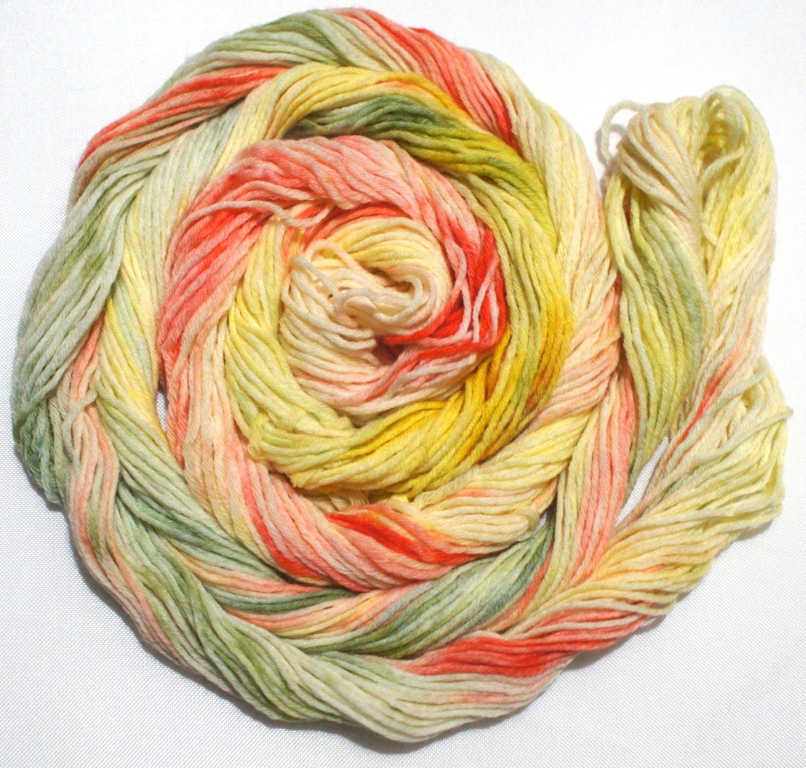 A bright swirl of yarn curls around itself like a labyrinth against a white background.