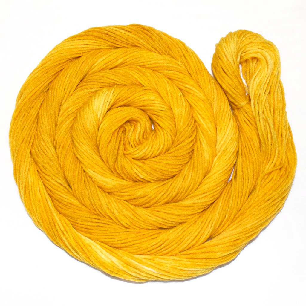 A bright swirl of yarn curls around itself like a labyrinth against a white background.
