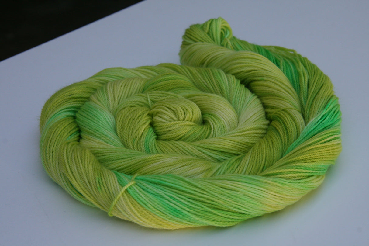 A swirling round of richly colored yarn rests against a clean white background.
