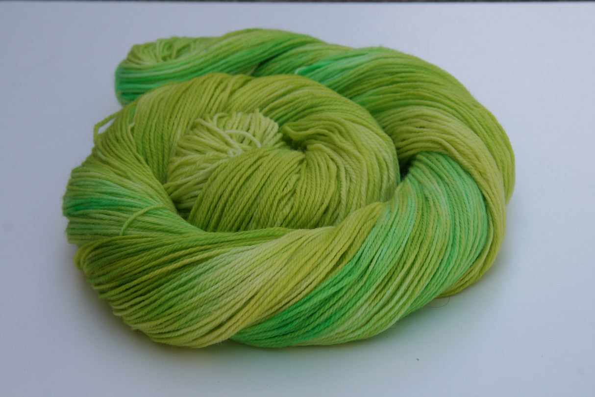 A bright swirl of yarn curls around itself like a labyrinth against a white background.