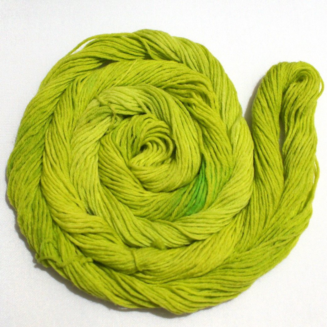 A swirling round of richly colored yarn rests against a clean white background.