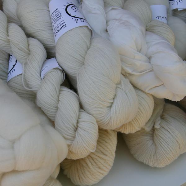 A pile of potential! Undyed skeins and roving braids in a pile.