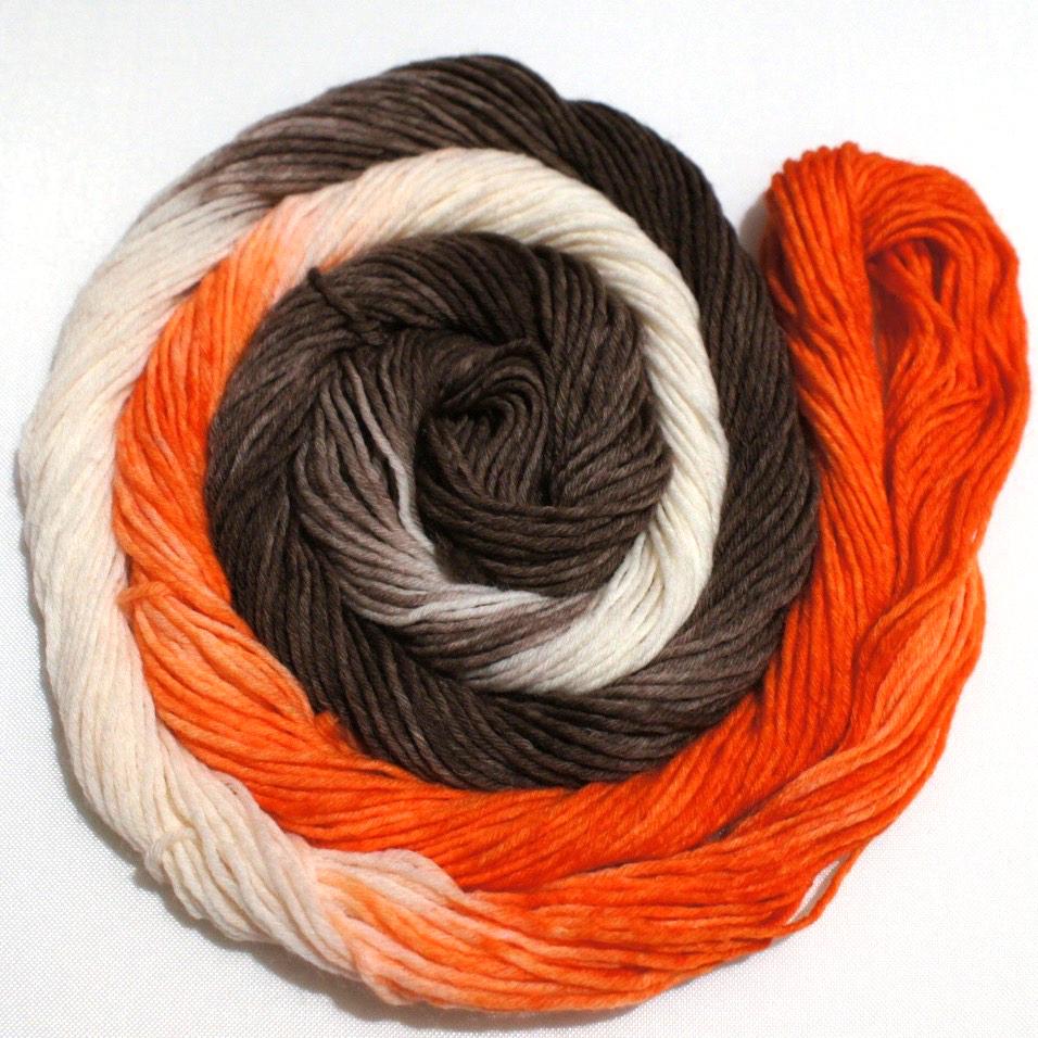 A bright swirl of yarn curls around itself like a labyrinth against a white background.