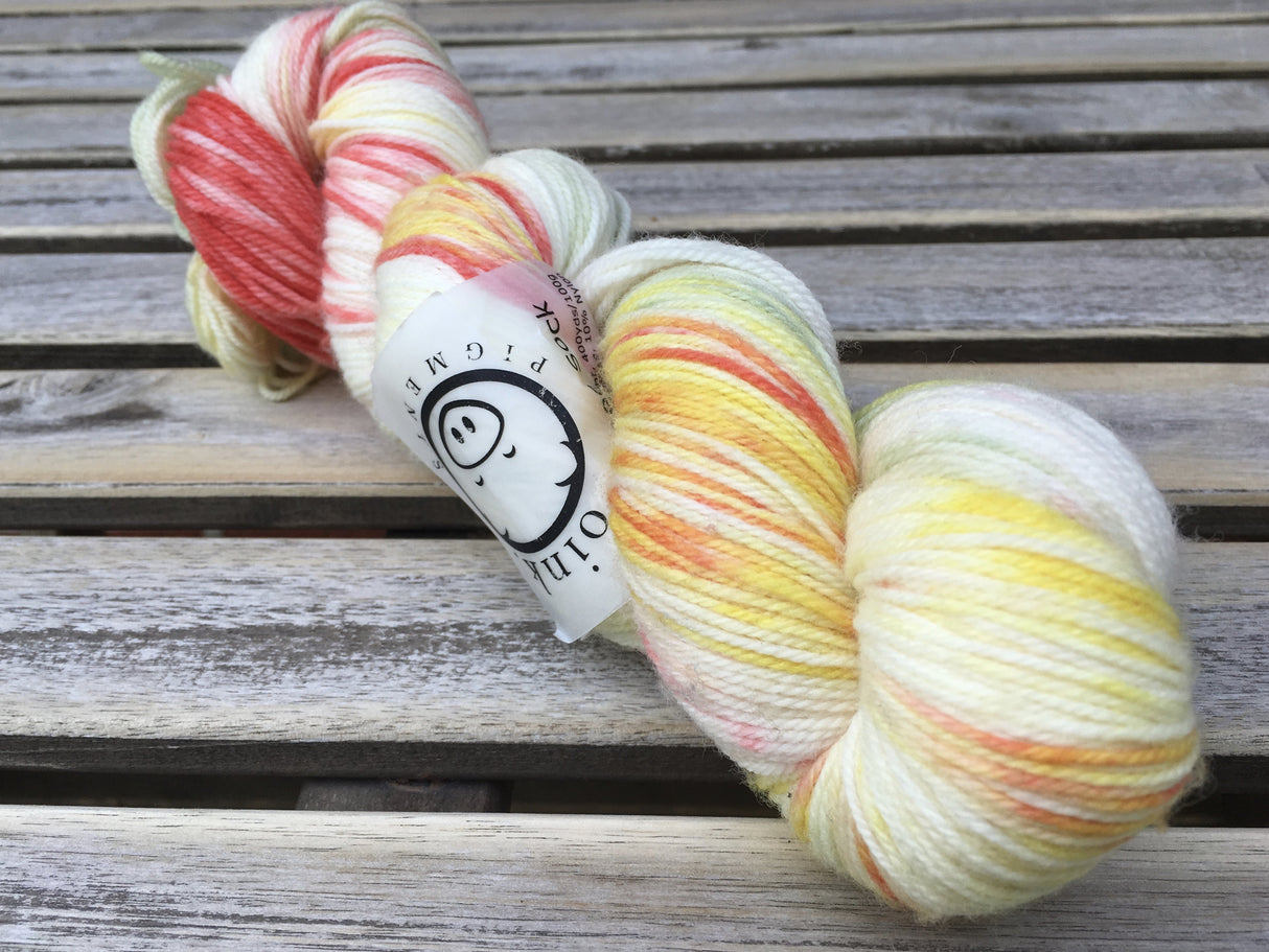 A single twist of yarn rests on a wooden background.