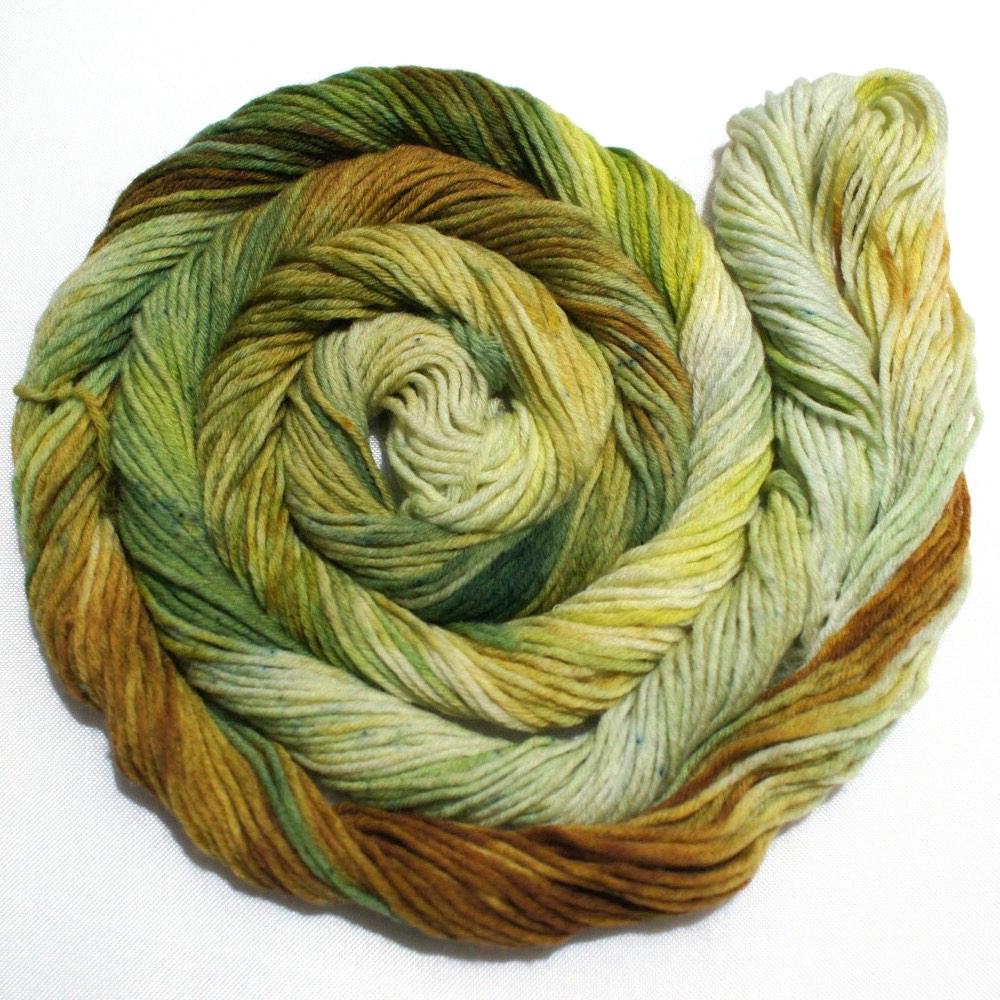 A swirling round of richly colored yarn rests against a clean white background.