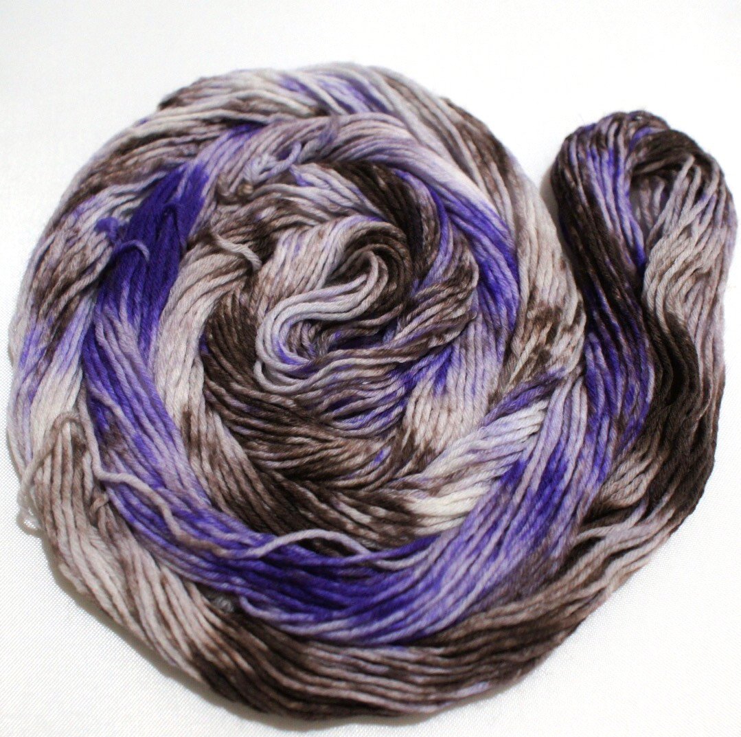 A bright swirl of yarn curls around itself like a labyrinth against a white background.