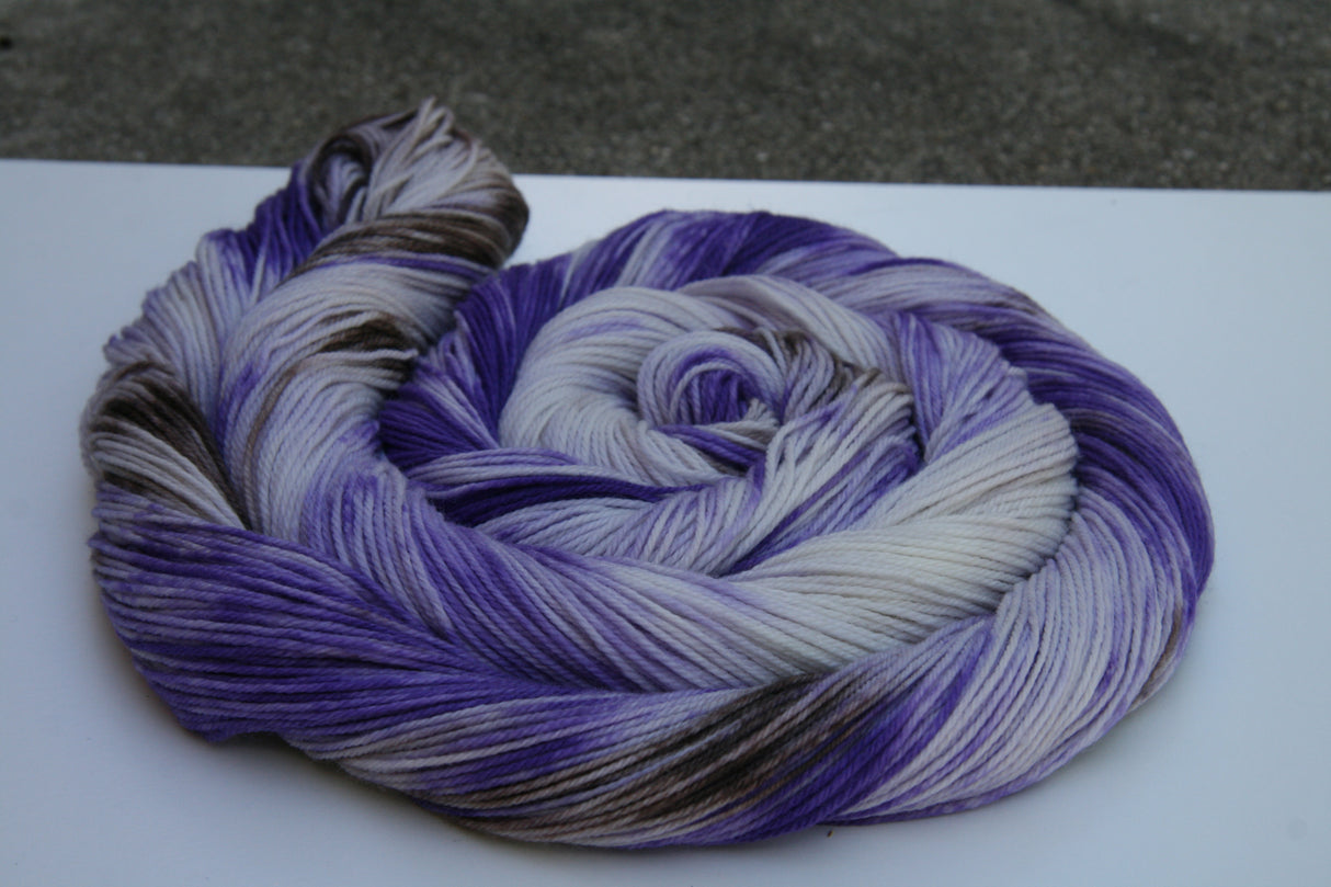 A colorful swirl of yarn curls around itself on top of a white background.