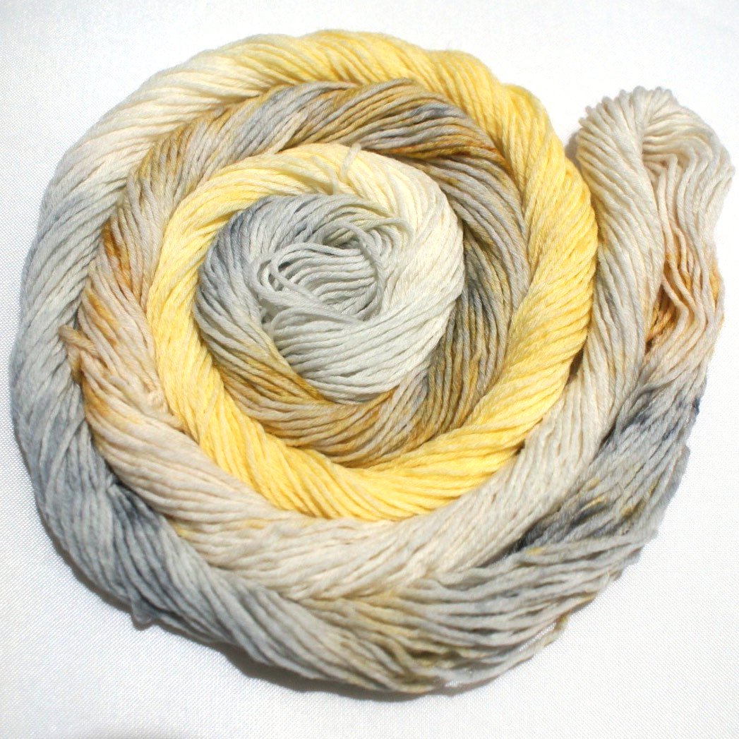 a bright swirl of yarn curls around itself like a labyrinth on a clean white background.