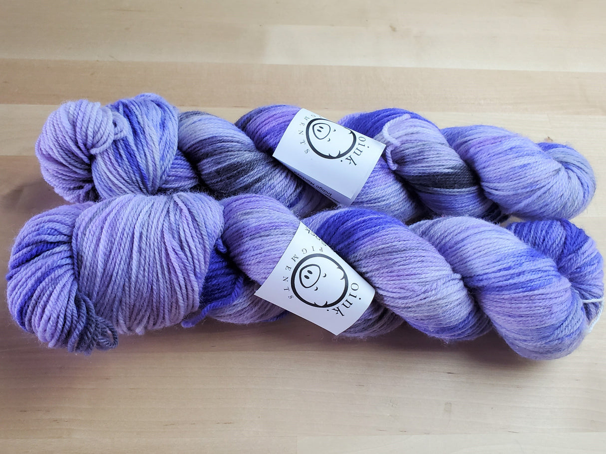 Two skeins rest on a light wooden background.