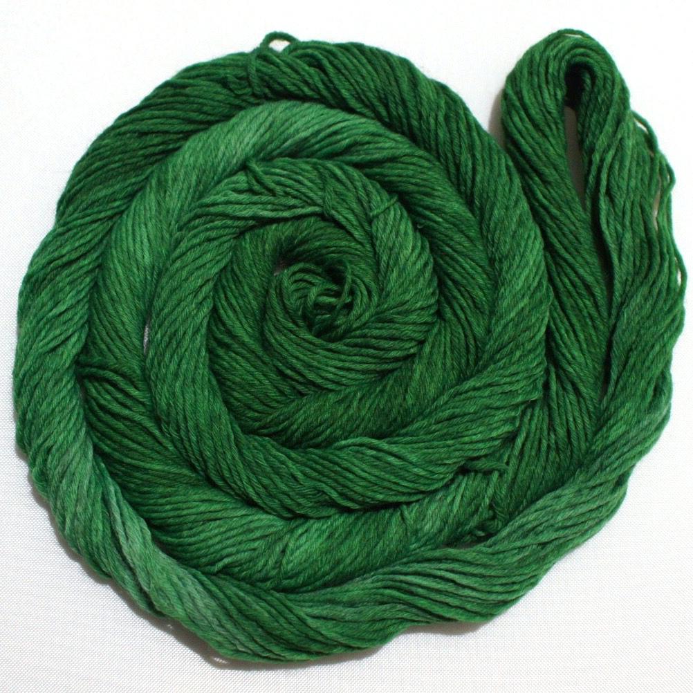 A rich swirl of yarn curls around itself like a labyrinth against a clean white background.