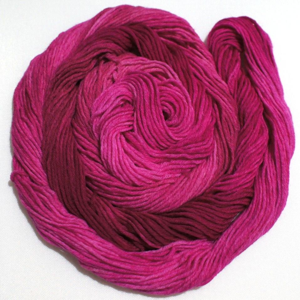 a whorl of yarn rests on a white background.