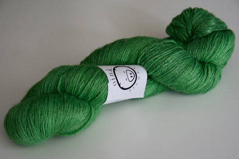 A single skein of yarn rests on a light grey background.