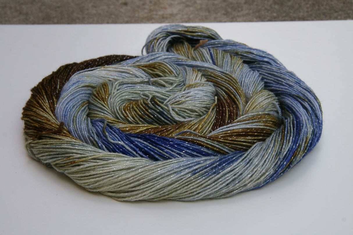 A bright swirl of yarn curls around itself like a labyrinth against a white background.