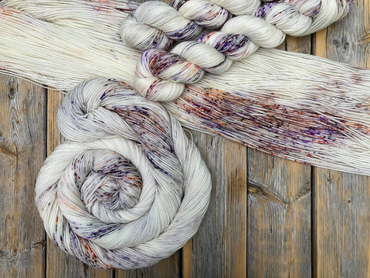 A dazzling array of yarn rests on a wooden tabletop.