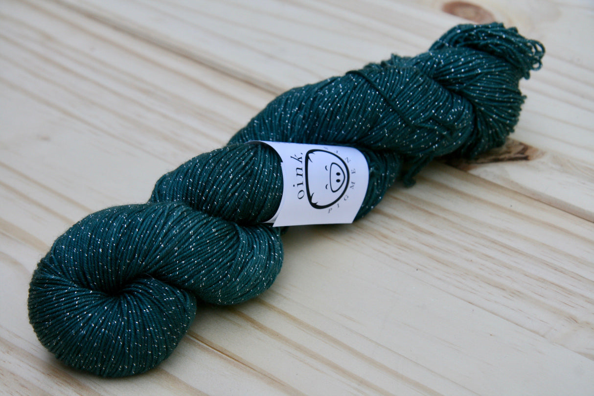 A richly colored twist of yarn rests on a wooden background.