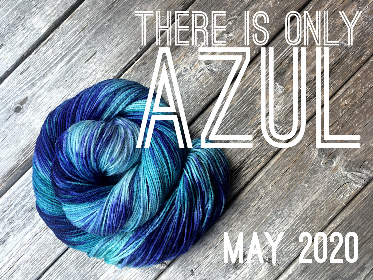 a skein of deep blue and lighter blue yarn sits in a twisted bun shape on top of a wooden background. White text reads "There is only Azul. May 2020"