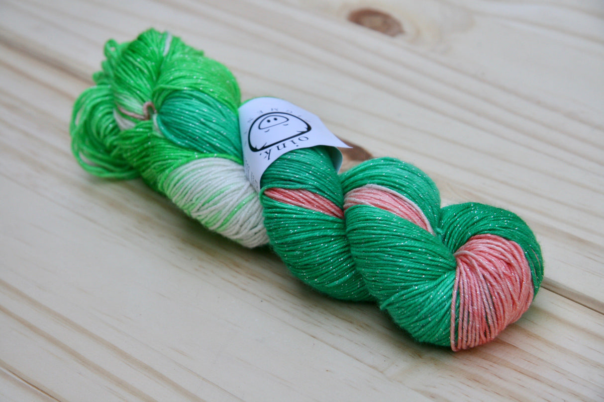 A richly colored twist of yarn rests on a wooden background.