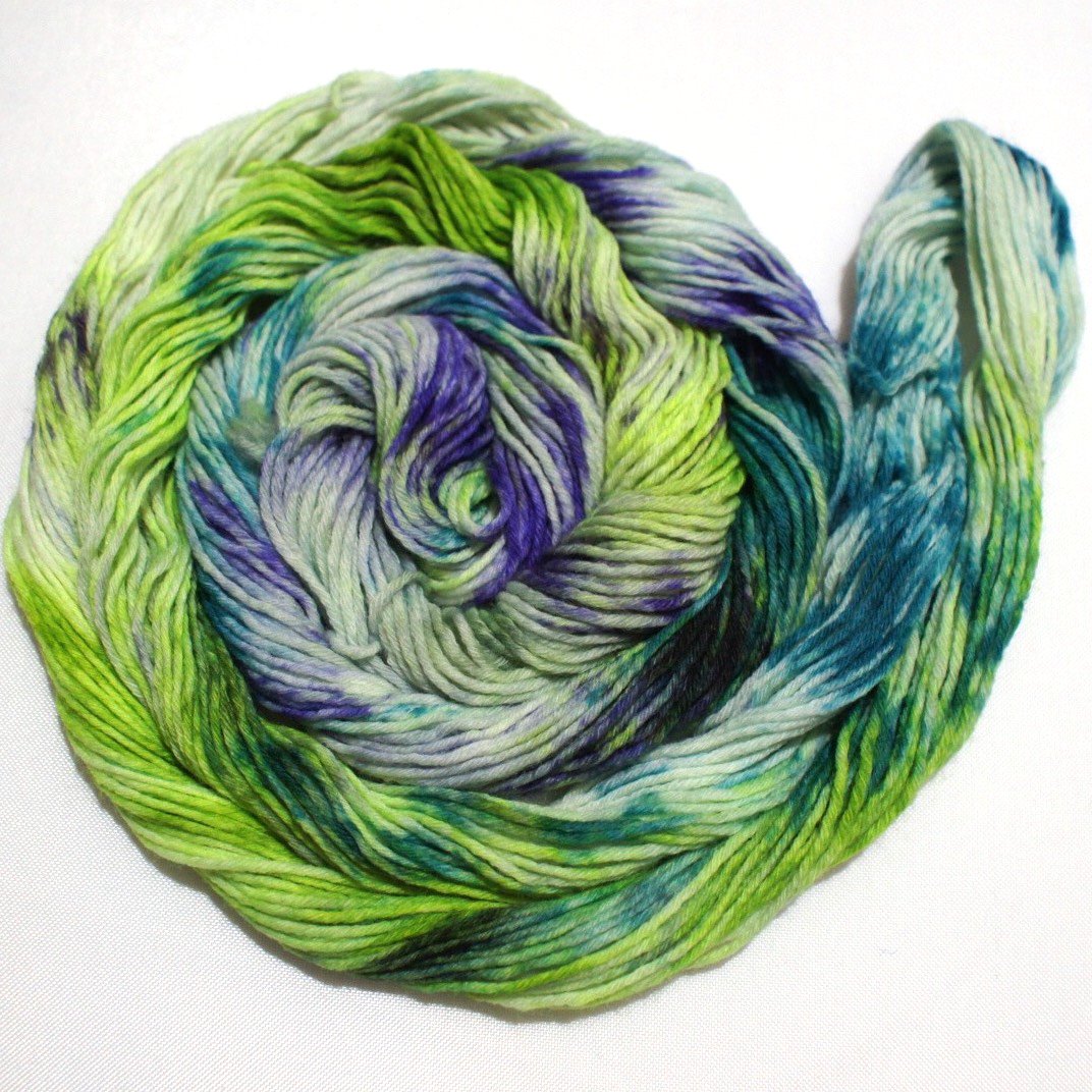 A bright swirl of yarn curls around itself like a labyrinth against a white background. 