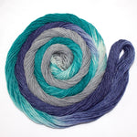 A bright swirl of yarn curls around its self like a labyrinth against a white background. 