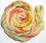 A bright swirl of yarn curls around itself like a labyrinth against a white background. 