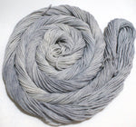 A soft grey swirl of yarn curls around itself like a labyrinth against a white background. 