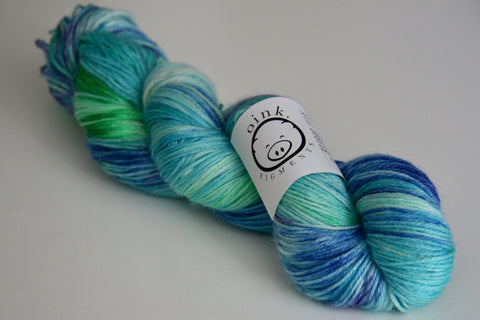 a bright and vivid skein of yarn rests on a white background. 