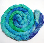 A bright swirl of yarn curls around its self like a labyrinth against a white background. 