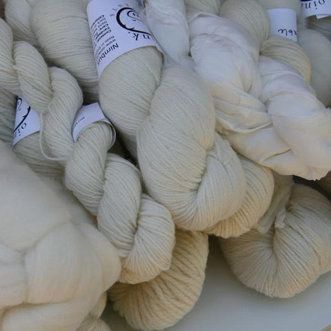 A pile of potential!  Undyed skeins and roving braids in a pile.