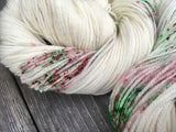 a close up on a skein of yarn, showcasing it's delicate twist and tiny speckles of color.