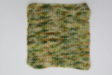 A crocheted swatch of Gecko Meadow rests on a clean white background. 