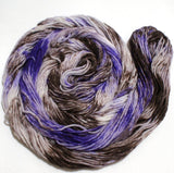 A bright swirl of yarn curls around itself like a labyrinth against a white background. 
