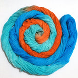 a bright swirl of yarn curls around itself like a labyrinth against a clean white background.