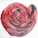 a swirl of bright yarn rests in a circle against a white background.