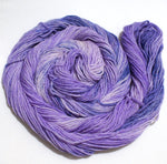 A swirl of yarn, loosened from its skein, rests on a white background.