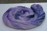 A swirl of yarn rests on a white background like a labyrinth.