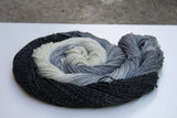 A swirling round of richly colored yarn rests against a clean white background. 