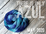 a skein of deep blue and lighter blue yarn sits in a twisted bun shape on top of a wooden background.  White text reads "There is only Azul. May 2020"